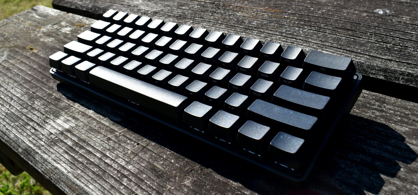 a computer keyboard sitting on top of a wooden table